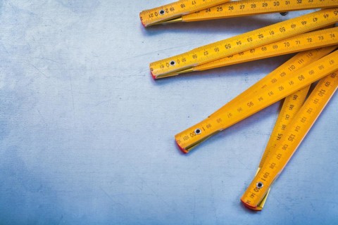 Copy space image of wooden metre on metallic background construction concept