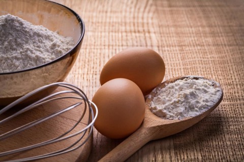 Corolla eggs flour in spoon and bowl on wooden board food and drink still life