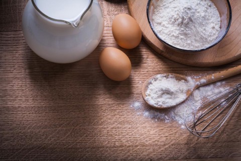Flour in bowl and spoon Flower crown Egg jug with milk on wooden board Food and drink Still life