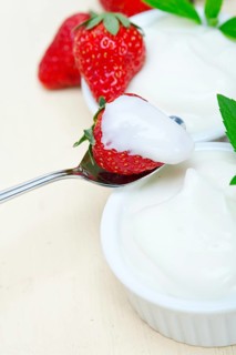 Organic Greek yogurt and strawberry over white rustic wood table