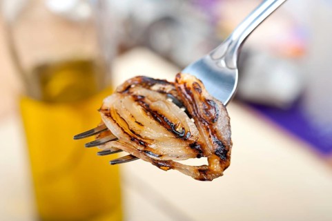 Grilled onion on a fork macro close up