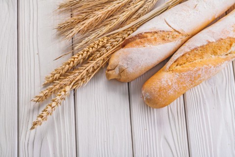 Composition two baguettes ears of wheat and rye on white boards Eating and drinking concept