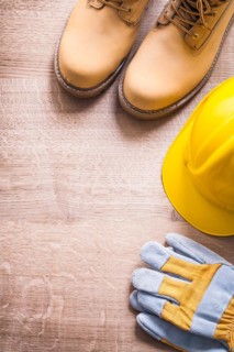 Organised copyspace working boots helmet gloves On Wooden Board