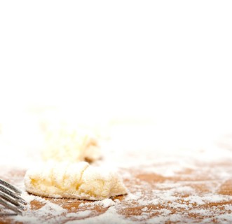 Making fresh Italian potato gnocchi on a wood rustic table