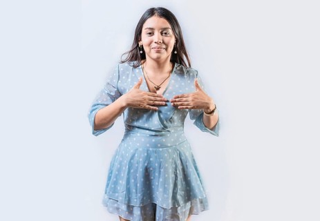 Girl gesturing the word THANKFUL in sign language. Person gesturing GRATEFUL in sign language