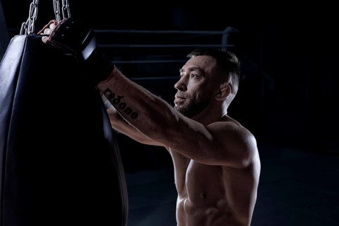 Kickboxer hooks a punching bag to a rope. Sports training. The concept of mixed martial arts. MMA