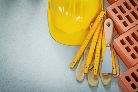 Composition of bricklaying tools on concrete background construction concept