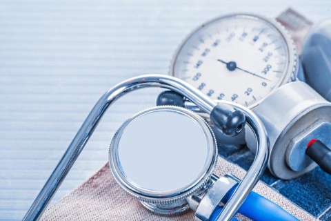 Stethoscope on blood pressure monitor on blue background medical concept