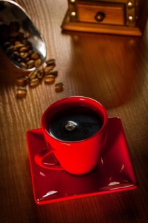 Coffee in a red cup on a wooden board