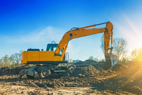 Excavator pouring ground from scoop