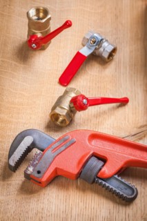 Monkey spanner and sanitary fittings on wooden board