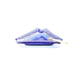Blue murano glass ashtray with lighted cigarette isolated on white background