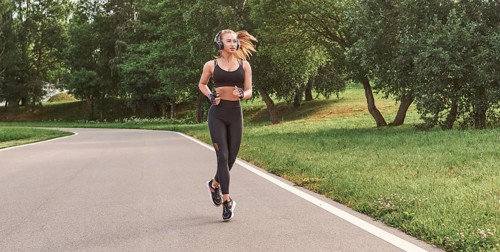 Fitness girl in sportswear runs through the evening sunny park. Healthy lifestyle. Mixed media