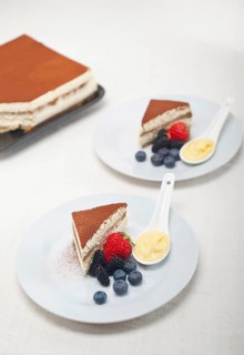 Classic Italian tiramisu dessert with berries and custartd pastry cream on side