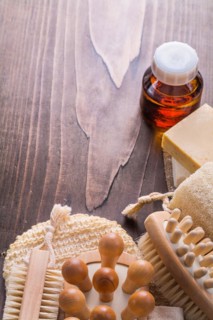 Classic wooden massagers Wisp brushes loofah soap and oil on vintage wooden board with copyspace