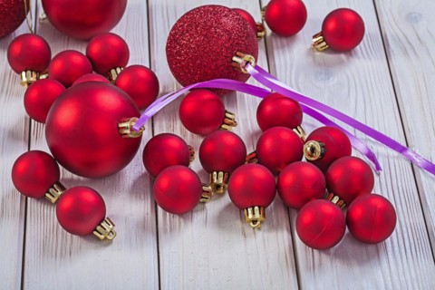 Lots of red Christmas baubles on white wooden boards