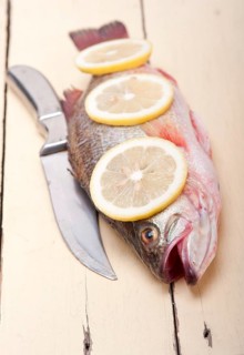 Fresh whole raw fish on a wooden table ready to cook