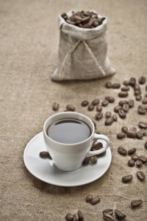 Coffee grains and a cup of coffee on a bag