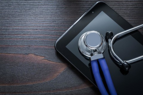 Horizontal version of stethoscope and tablet on vintage wooden background medicine concept