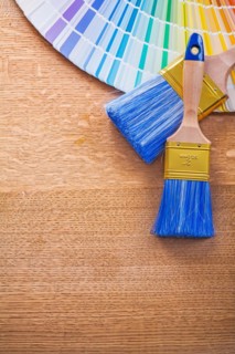 Multi coloured Pantone fan and brush on wooden board construction concept