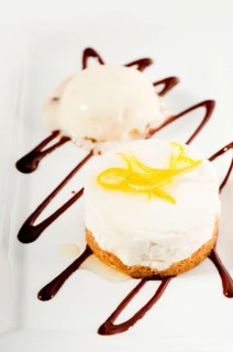 Very elegant lemon mousse dessert served whith lemon peel on top and vanilla ice cream on side