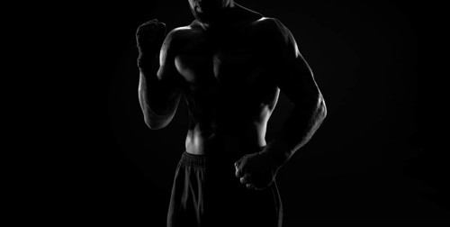 Noname image of a kickboxer on a dark background. The concept of mixed martial arts. MMA