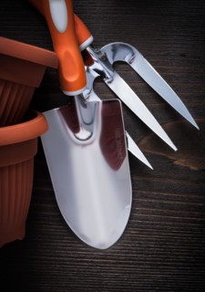 Clay planting pots trowel fork and hand spade on vintage wood board close up image gardening concept