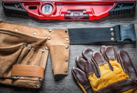 Construction level protective gloves leather toolbelt on wooden board