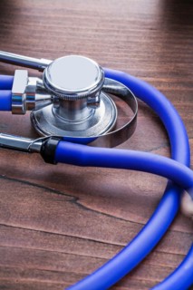 Blue medical stethoscope on vintage wooden board