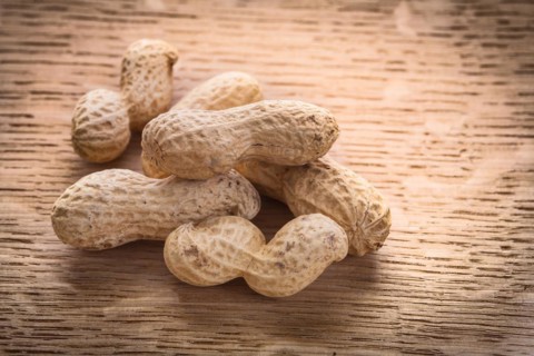 Small pile of peanuts on wooden board Food and drink concept