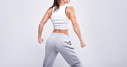 No name portrait. Young white fitness woman wearing sportswear standing over white wall background. Fitness concept. Mixed media
