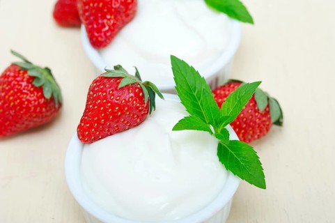 Organic Greek yogurt and strawberry over white rustic wood table