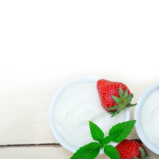 Organic Greek yogurt and strawberry over white rustic wood table