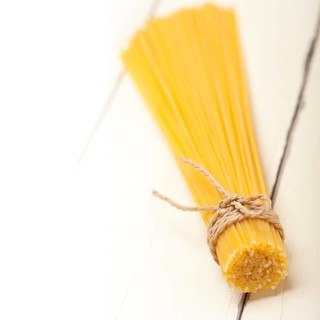Italian pasta spaghetti tied with a rope on a rustic table