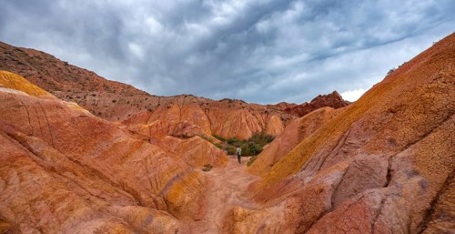 Tourist hikes through canyon of eroded sandstone formations