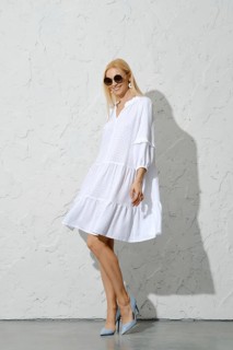 Cute woman in white cotton sundress and high heel shoes posing