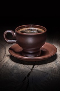 Brown clay coffee cup on vintage wood