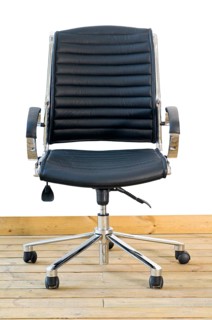 Modern black leather office chair on wood floor over white background