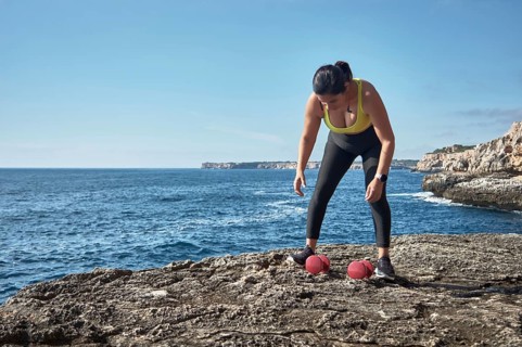 FITNESS LATIN WOMAN IN SPORTS SET TRAINING WITH ELASTIC BAND