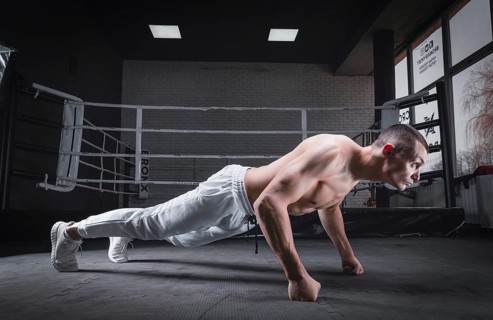 Muscular man doing push-ups in the gym. Fitness concept.