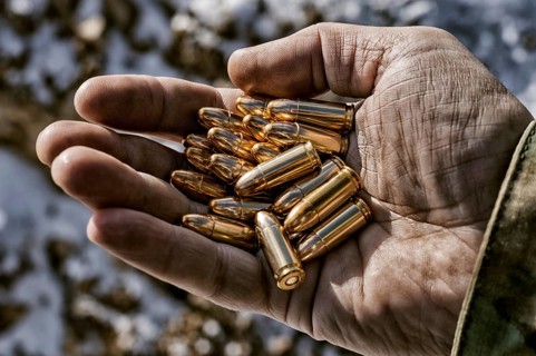 The fighter holds a handful of bullets in his palm for weapons.