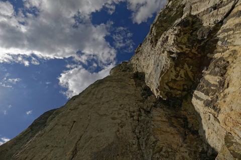 Striking limestone rock formation Burgstein with blue and white sky in the upper Altmuehltal surrounded by green vegetation