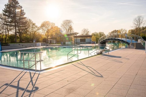 Long shadows and sparkling water in a swimming pool during a sunset