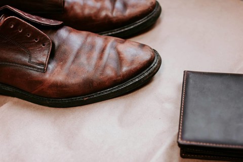 Brown men's shoes made of genuine leather and a brown leather wallet with money