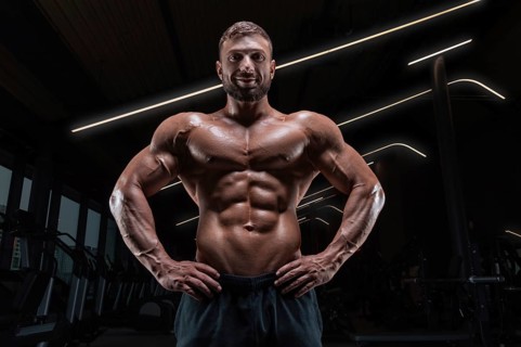 Image of a muscular guy with a naked torso and abs. Gym. Fitness concept