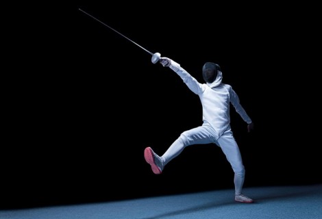 The fencer moves forward with a sword in his hand. Sport concept.
