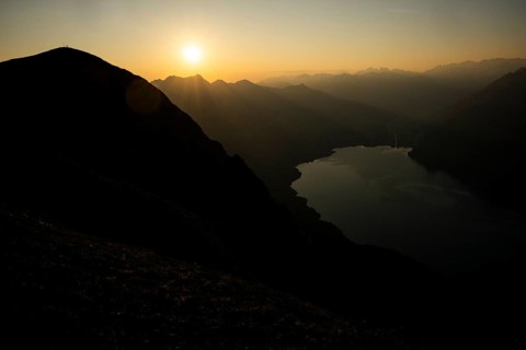 Mountain ridge with mountaineers and Swiss mountains and Lake Thun in the background at sunrise