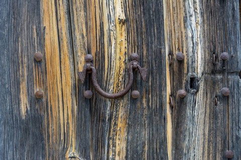 Old wooden door with aged metal door handle. Architectural textured background