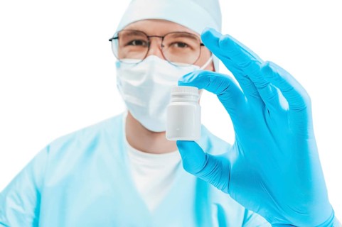 Portrait of a doctor with a jar of pill in hand. White background. Medicine concept.