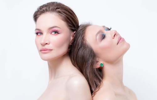 Portrait of two beautiful girls with defiant make-up on a white background. Female friendship concept. High quality